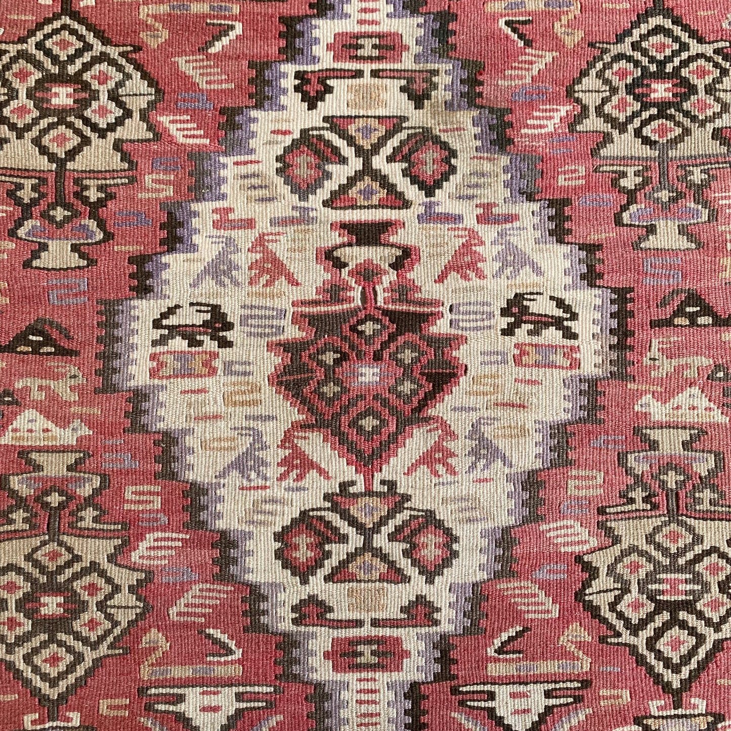 Close up detail of central medallion on Kurdish Senneh kilim rug with geometric and animal motifs